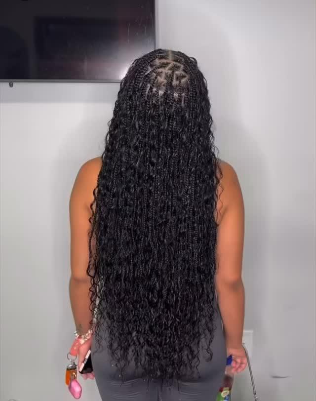 Dark boho knotless braids with loose curls falling along the length